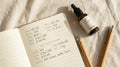 CBD dosage tracker journal with amber dropper bottle on cream linen