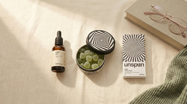 Product flatlay on cream linen showing oil, gummies and chocolate