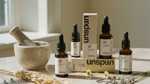 How We Make CBD Oil - Unspun oil bottles with dried botanicals