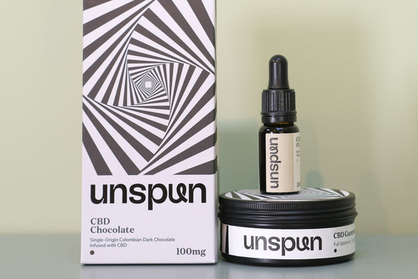 unspun CBD chocolate box, oil bottle and gummies tin