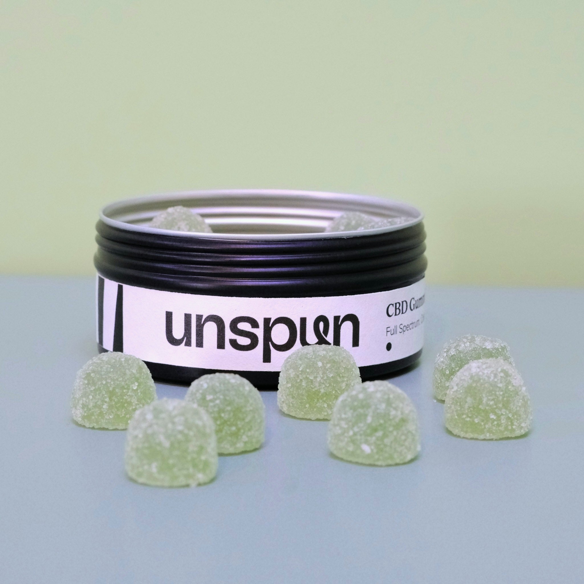 Unspun Full Spectrum CBD Gummies — open tin with green sugar-coated gummies