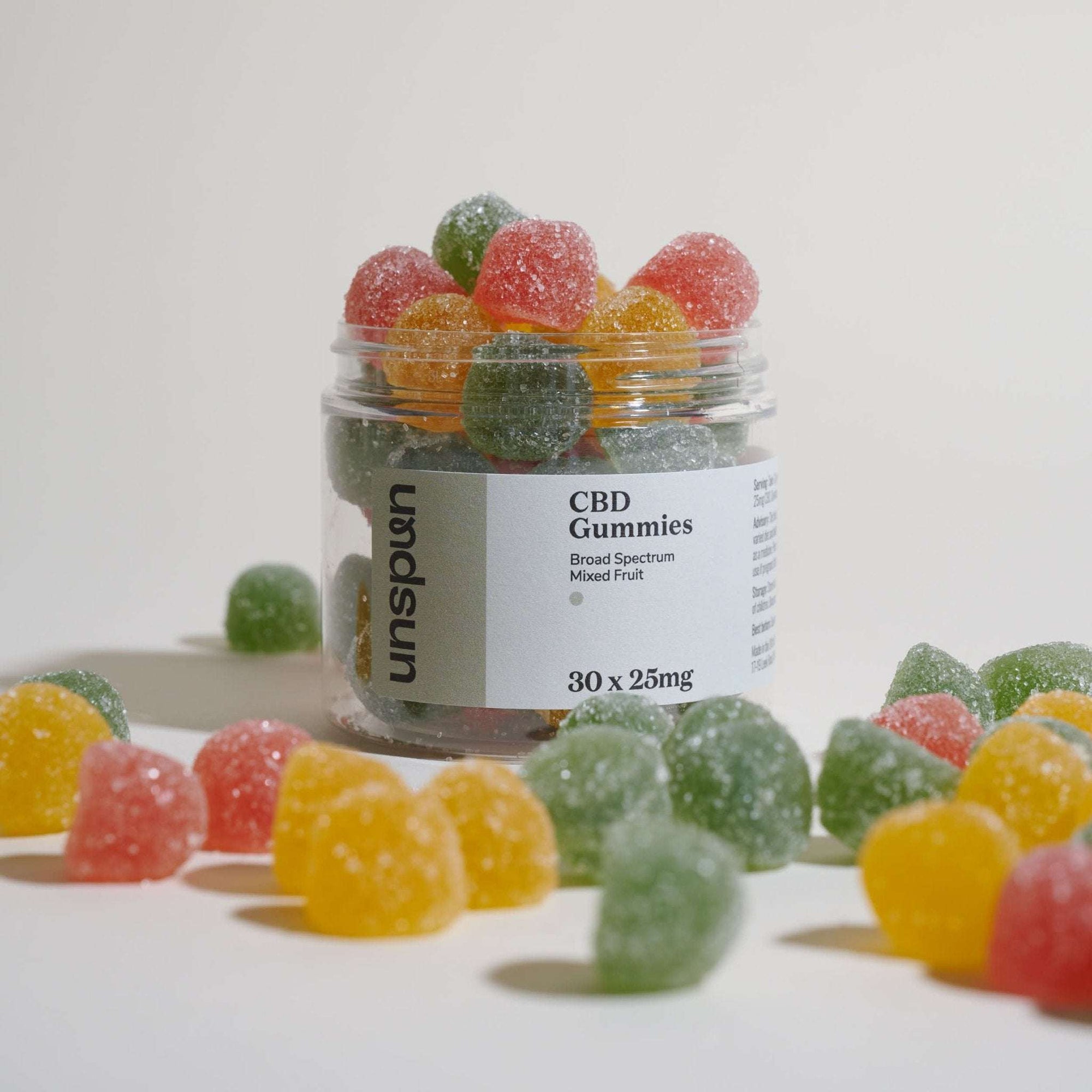 Unspun Broad Spectrum CBD Gummies with gummies overflowing from packaging 